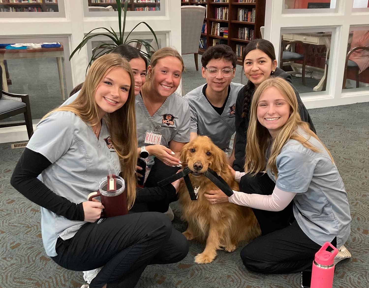 6 CNAs with a service dog at senior living